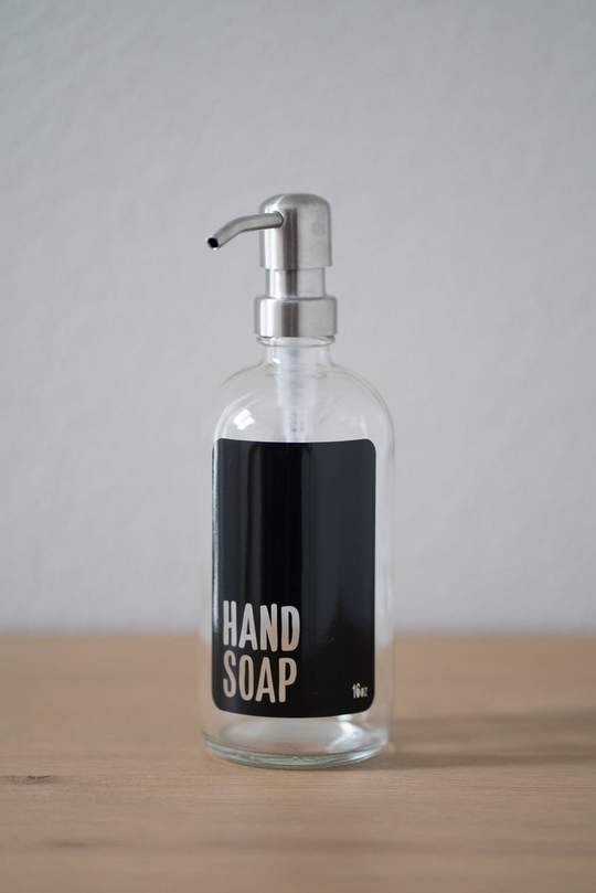 https://urbanember.com/cdn/shop/products/CLMOBLHSASP-clear-glass-modern-black-hand-soap-stainless-steel-pump_1024x1024.jpg?v=1613591640