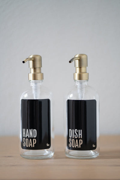 Clear glass with black hand and dish soap bottle set with brass pumps